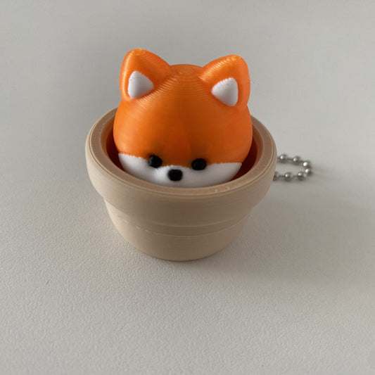 Clicker fidget porte-clés renard kawaii CLADEA, installé dans son pot