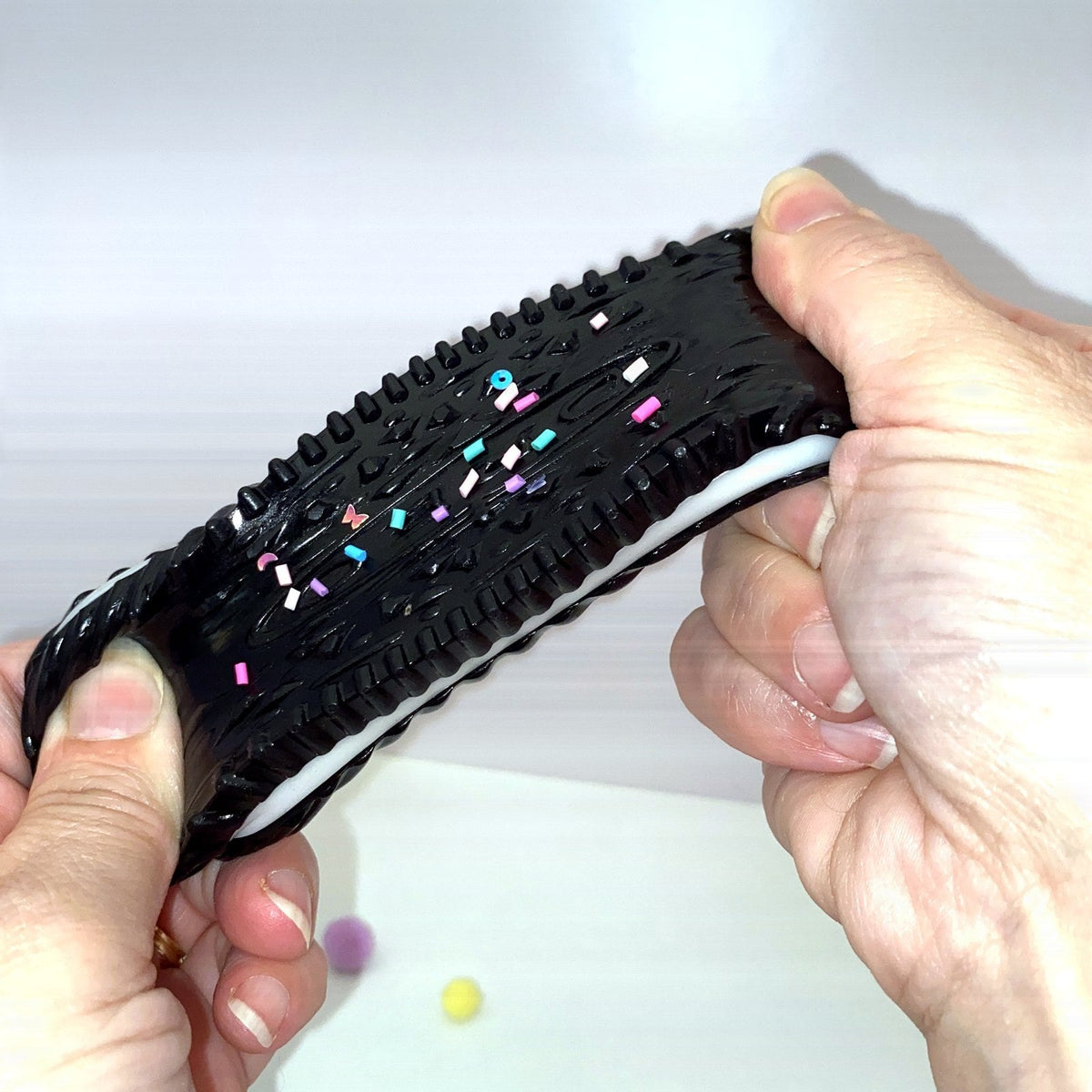 Squishy cookie noir CLADEA étiré en longueur, matière souple et résistante