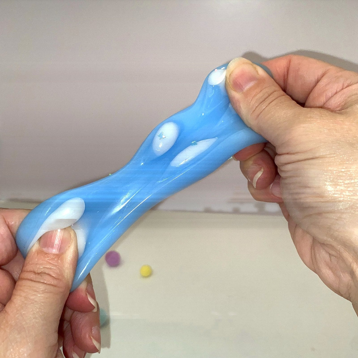Squishy patte de chat bleue CLADEA étirée, démonstration de l'élasticité